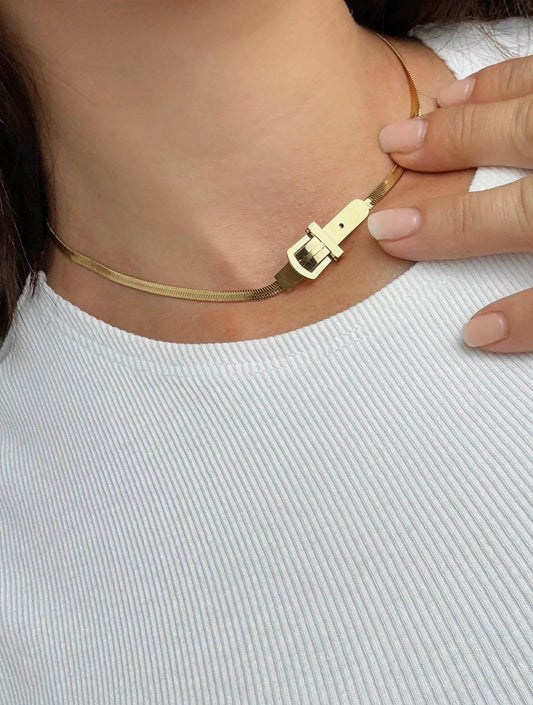 Collar dorado de diseño exclusivo Mykoani con cierre original sobre cuello en blusa blanca.