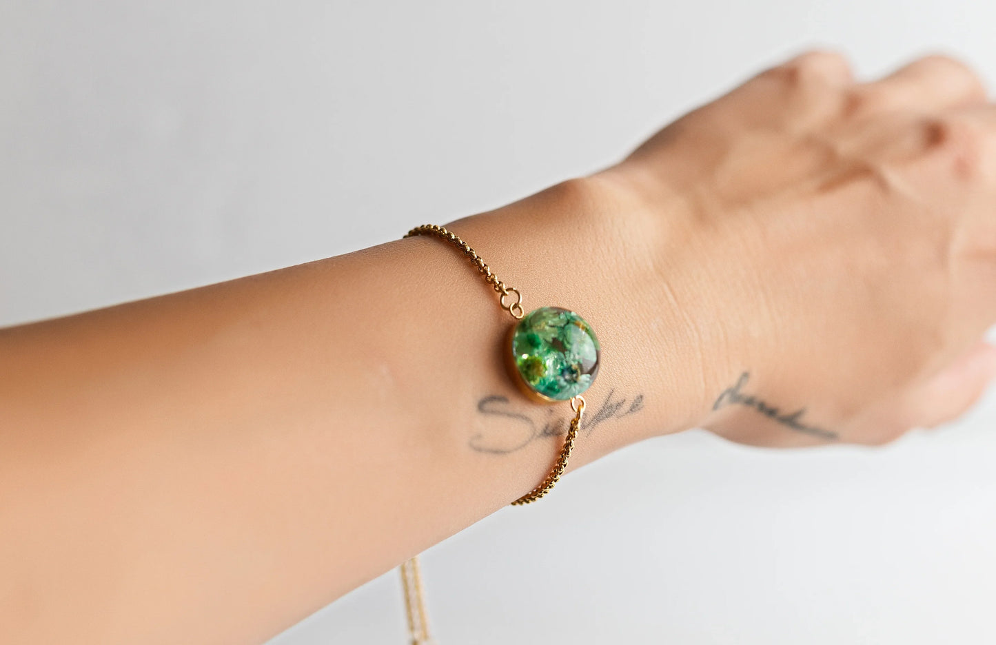 PULSERA JARDÍN ESMERALDA EN RESINA CON BAÑO DE ORO Y ACERO INOXIDABLE