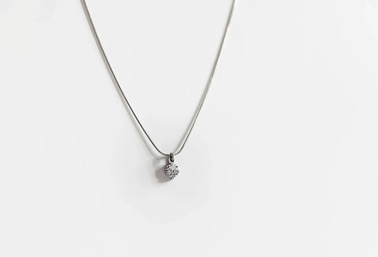 Collar de bisutería fina MYKOANI con dije brillante sobre fondo blanco, diseño exclusivo.