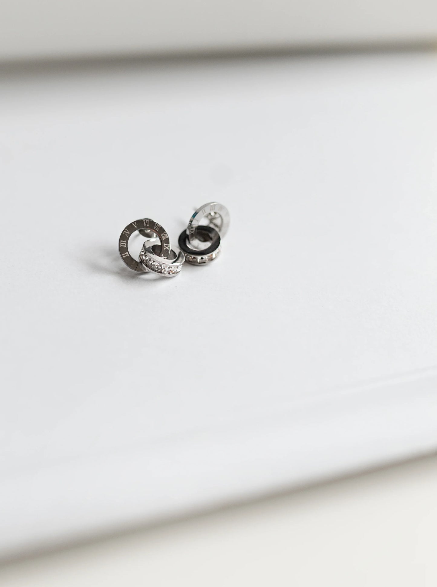 Aretes de bisutería fina MYKOANI plateados con aros y detalles de números romanos