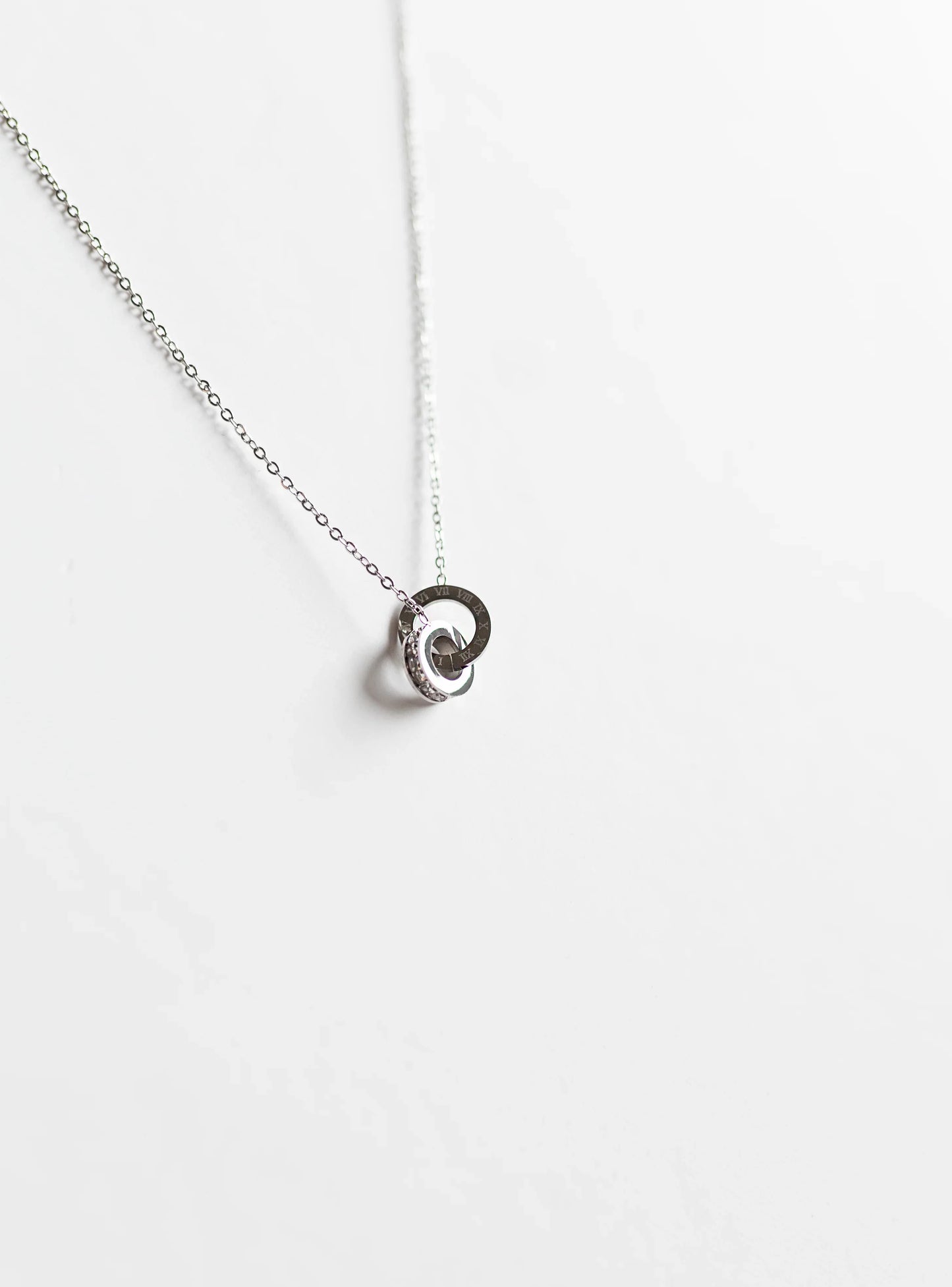 Collar de bisutería fina MYKOANI con dije circular plateado sobre fondo blanco