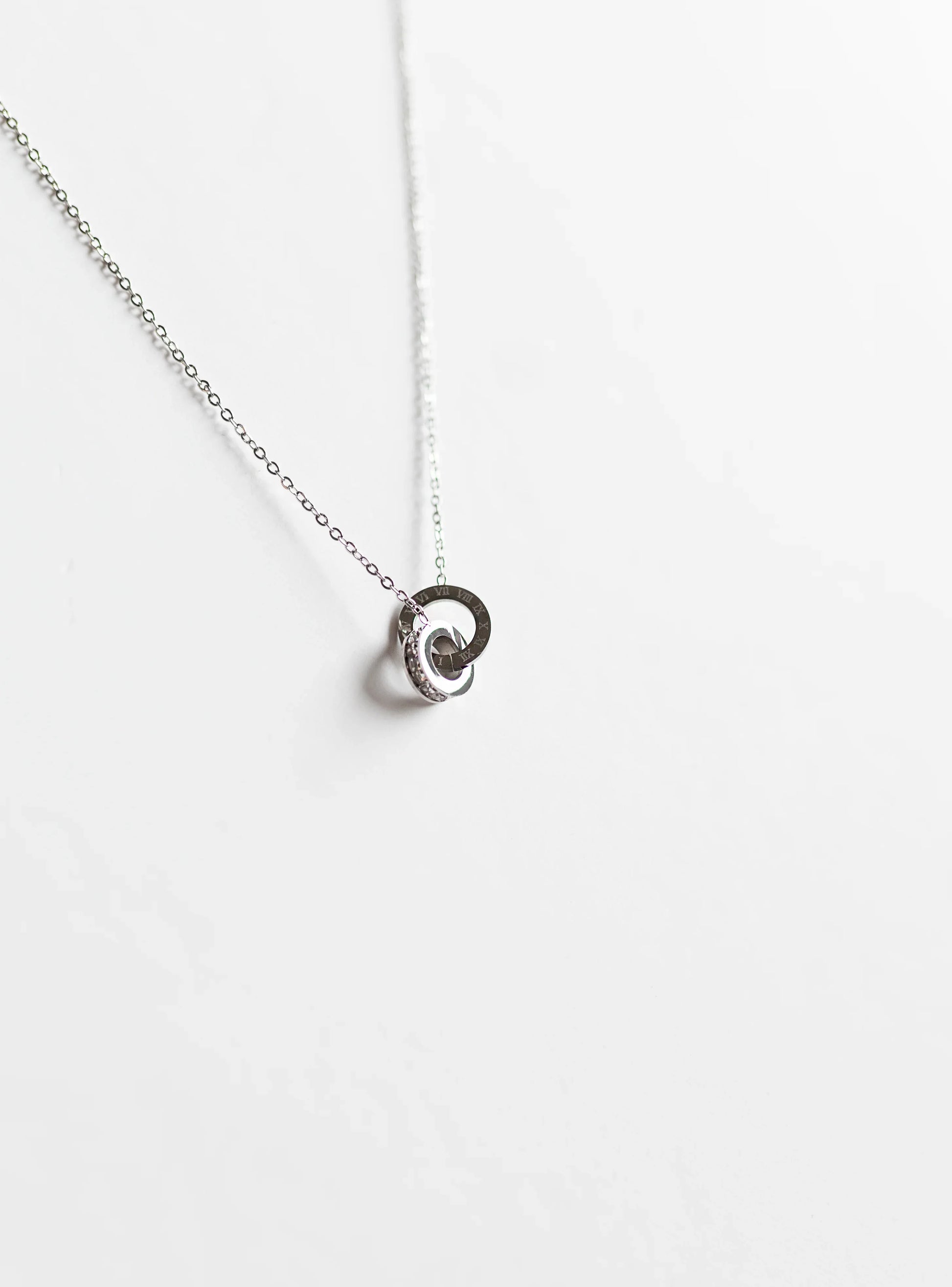 Collar de bisutería fina MYKOANI con dije circular plateado sobre fondo blanco