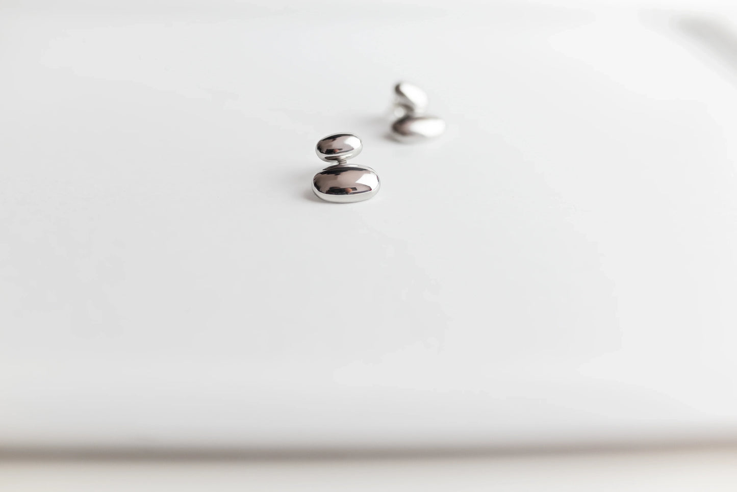 Pendientes de bisutería fina MYKOANI plateados de diseño minimalista sobre fondo blanco