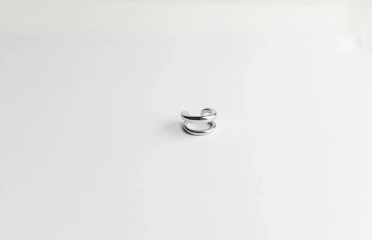 Ear cuff plateado de diseño minimalista, alta bisutería exclusiva MYKOANI sobre fondo blanco